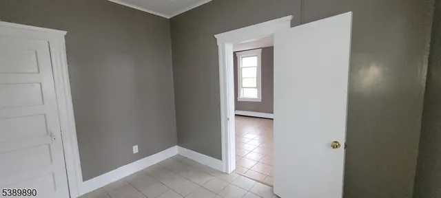 a view of an empty room with closet and a bathroom