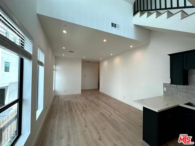 a view of a hallway with wooden floor and furniture