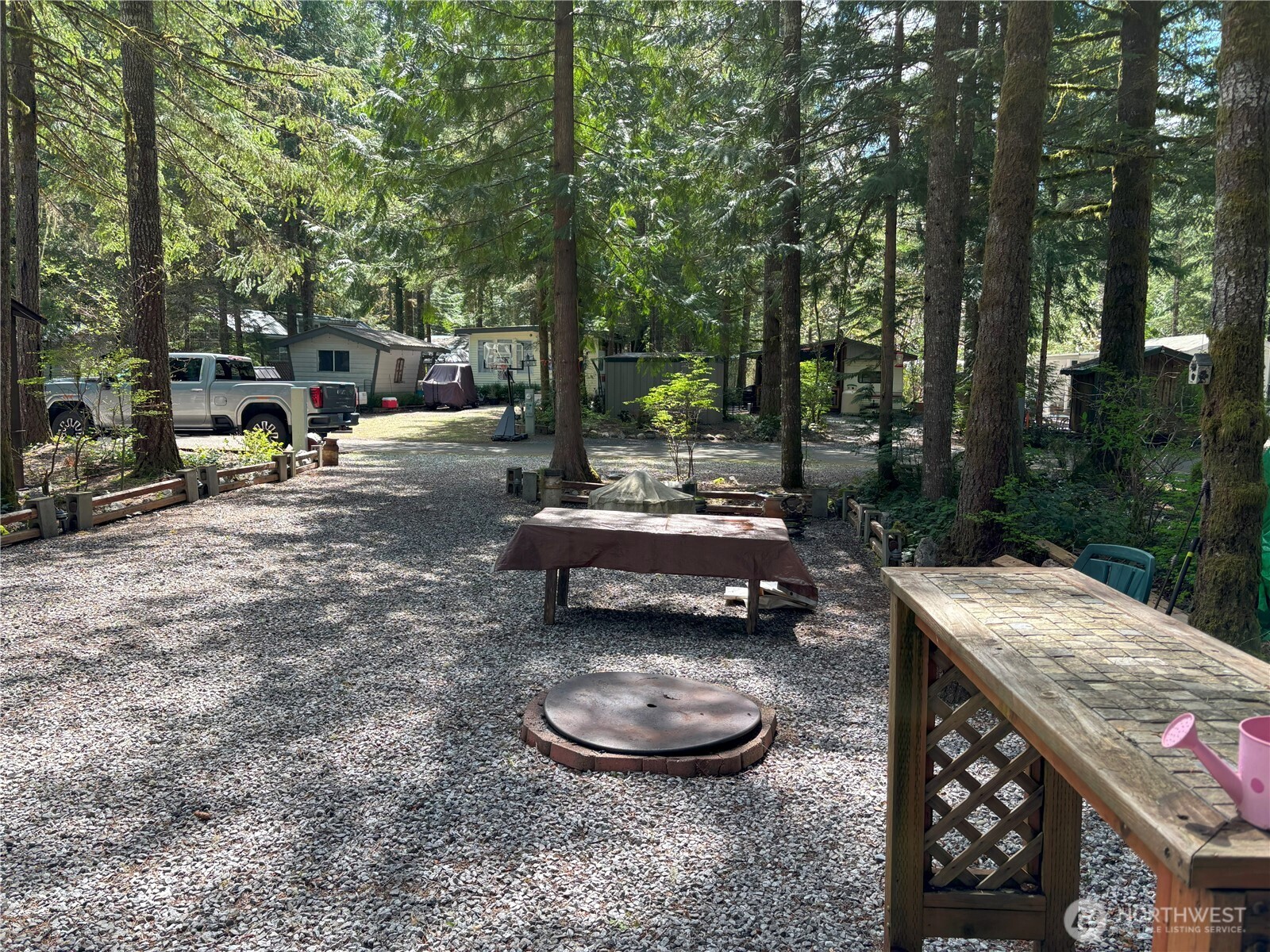 24-4 Drial Loop Maple Falls, WA 98266 - Photo 16 of 16 a view of a patio with table and chairs a fire pit and a large tree
