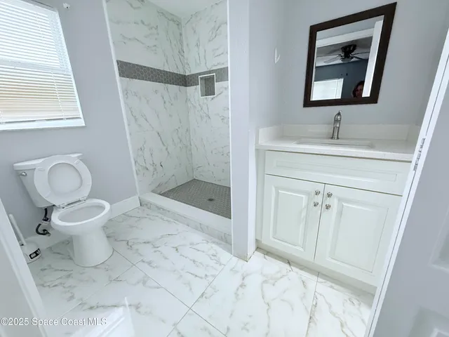 a bathroom with a shower sink and mirror