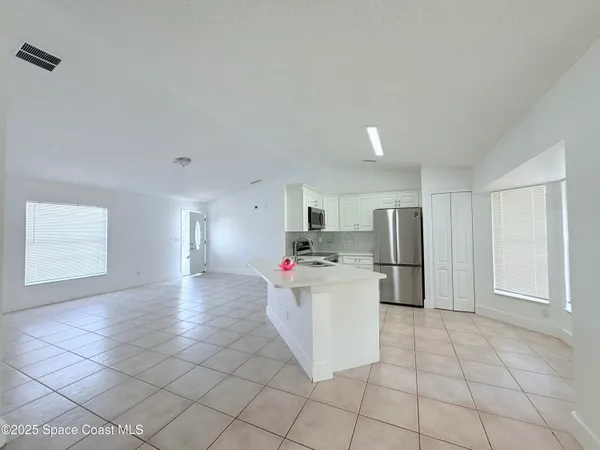 a view of a kitchen with refrigerator and microwave