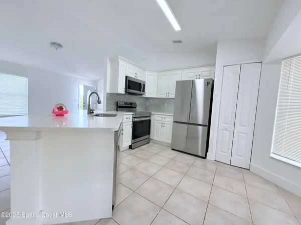 a kitchen with stainless steel appliances granite countertop a refrigerator sink and cabinets