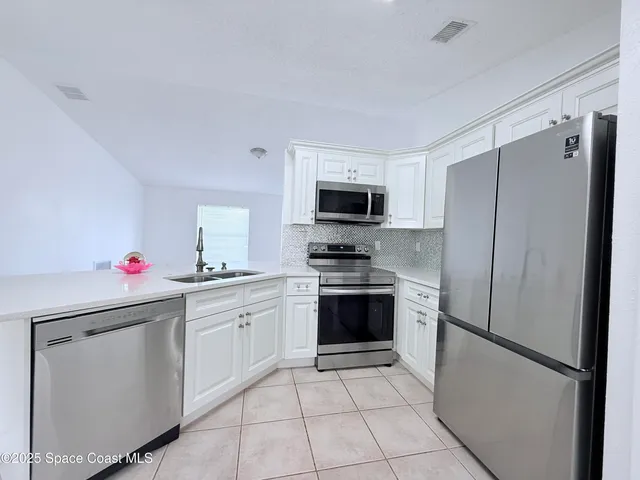 a kitchen with cabinets stainless steel appliances and a counter space