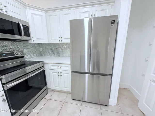 a kitchen with stainless steel appliances granite countertop a refrigerator a microwave a sink and cabinets