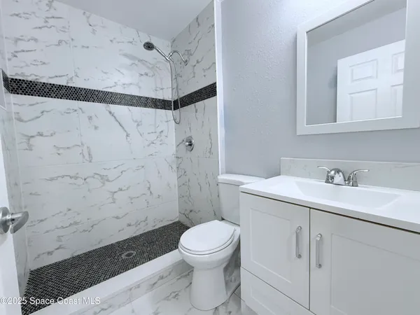 a bathroom with a sink a toilet and a mirror