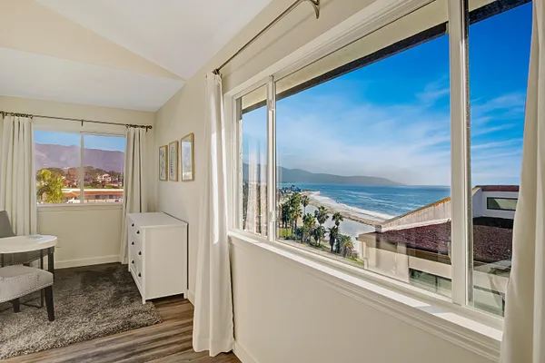 a living room with furniture and a floor to kitchen view