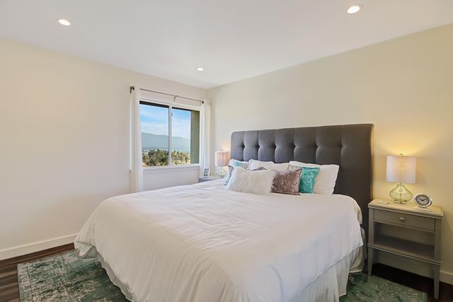 a large bed sitting in a bedroom next to a window