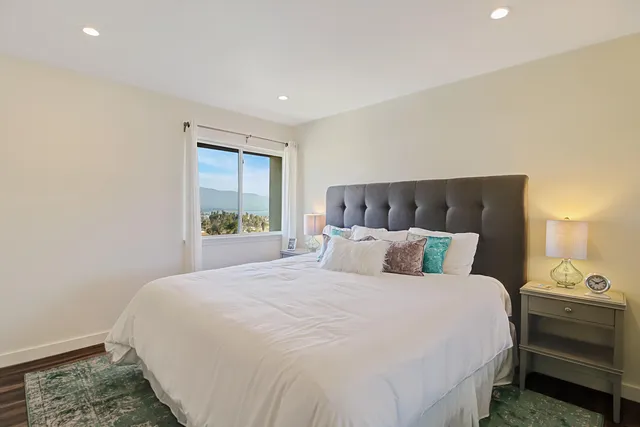 a large bed sitting in a bedroom next to a window