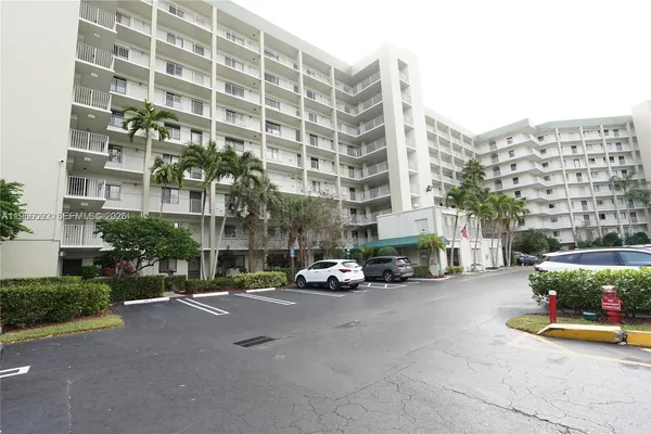a view of a building with cars parked