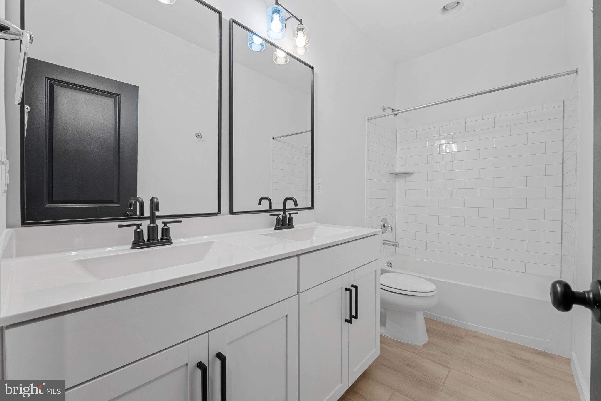 18080 Moss Garden Road Dumfries, VA 22026 - Photo 36 of 76 a bathroom with a double vanity sink toilet and mirror