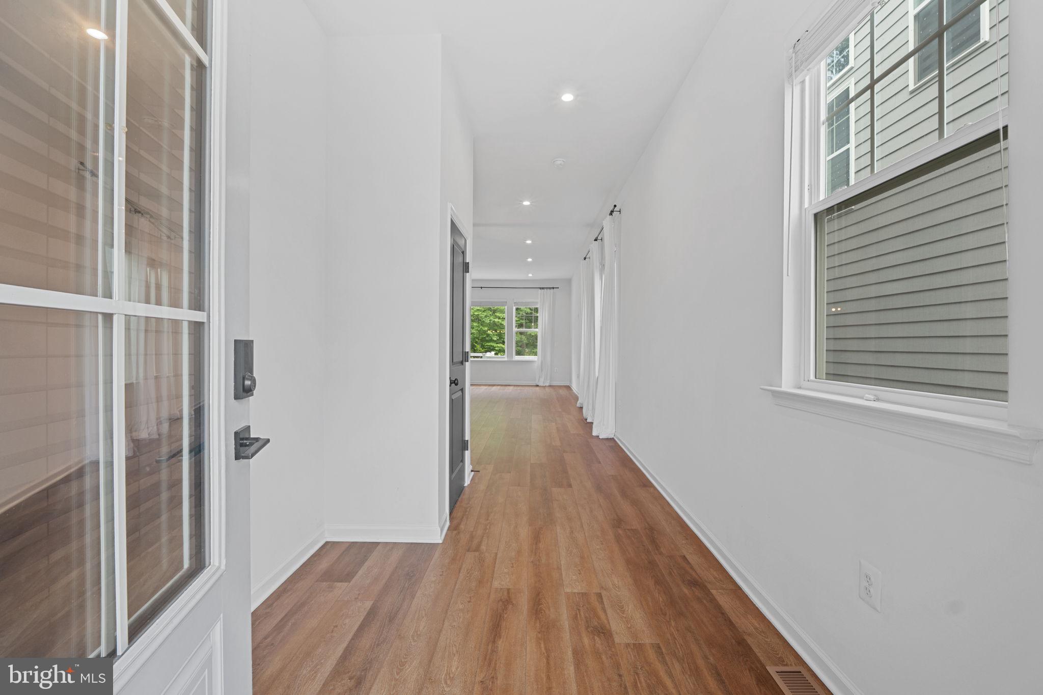 18080 Moss Garden Road Dumfries, VA 22026 - Photo 5 of 76 a view of a hallway with wooden floor and a bathroom