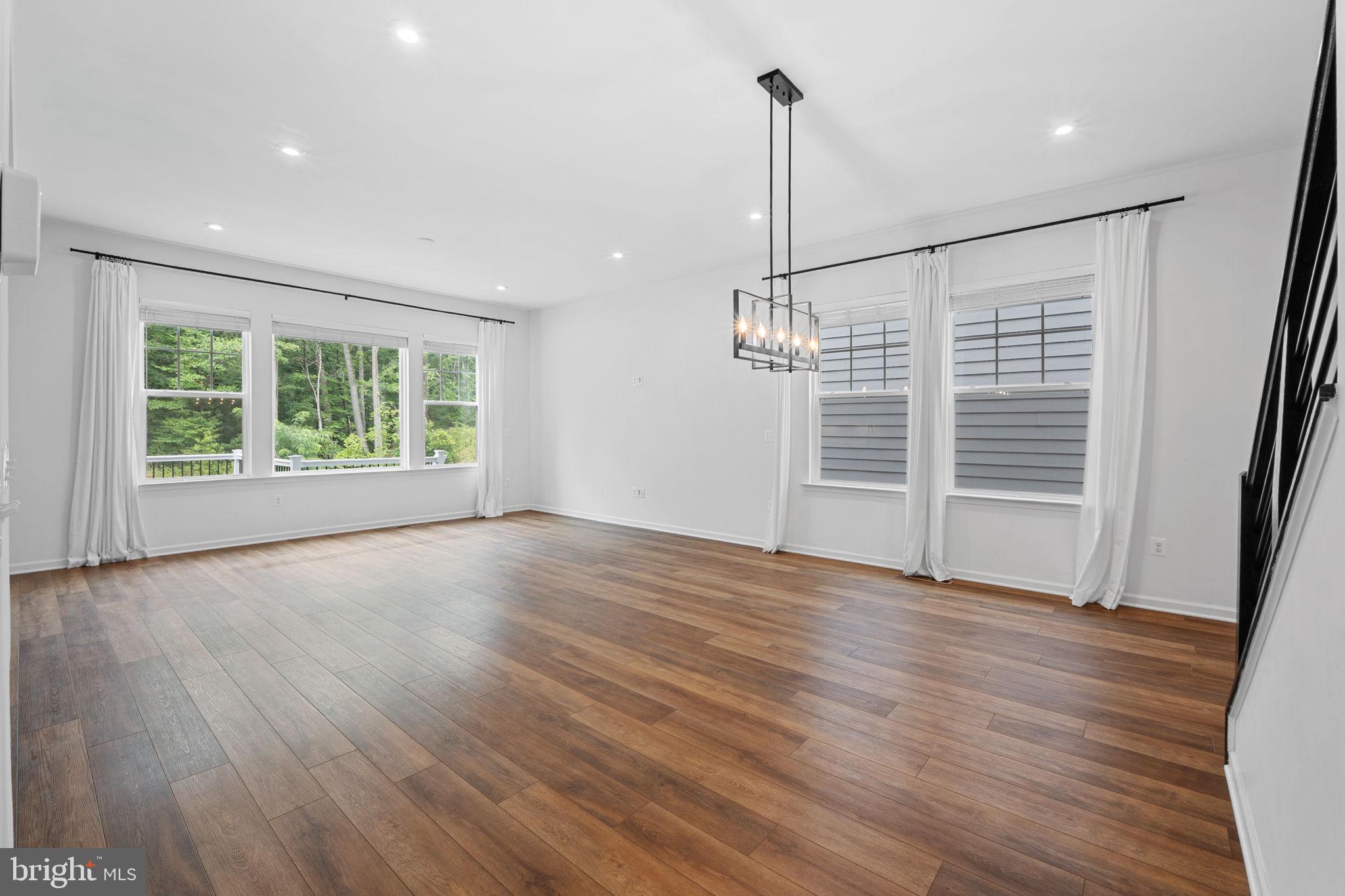 18080 Moss Garden Road Dumfries, VA 22026 - Photo 7 of 76 a view of an empty room with wooden floor kitchen view and a window