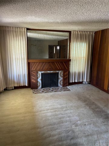 an empty room with wooden floor and fireplace