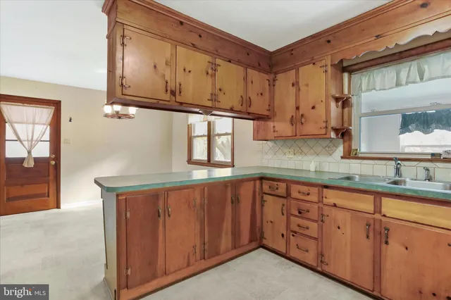 a kitchen with stainless steel appliances granite countertop a sink and cabinets with wooden floor