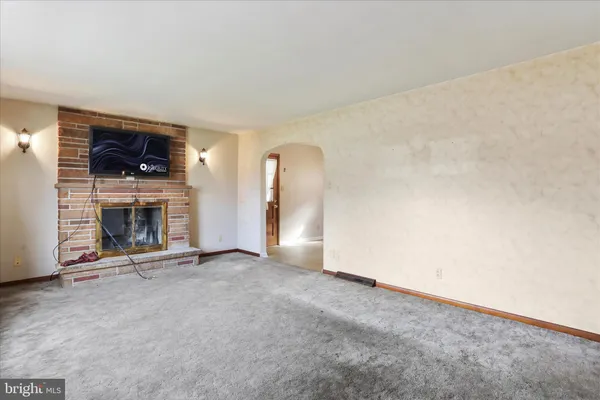 an empty room with a fireplace and window