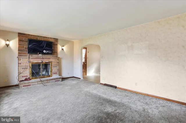 an empty room with a fireplace and window
