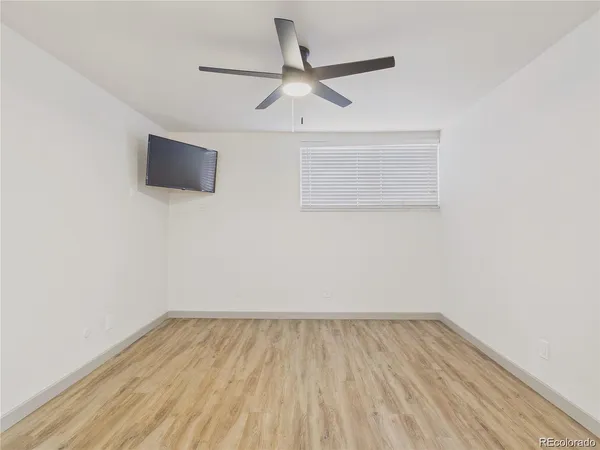 a view of a room with wooden floor and a ceiling fan