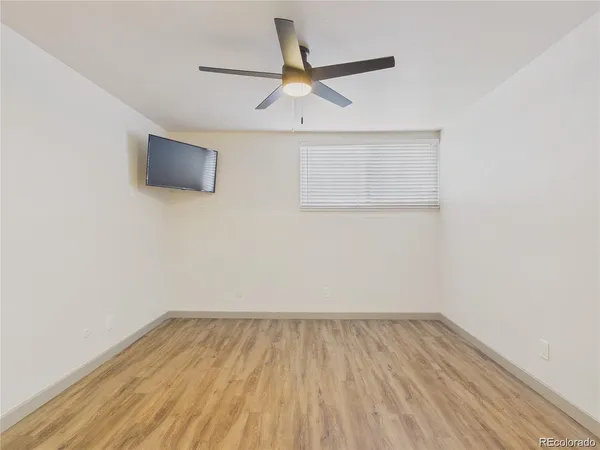 a view of a room with wooden floor and a ceiling fan