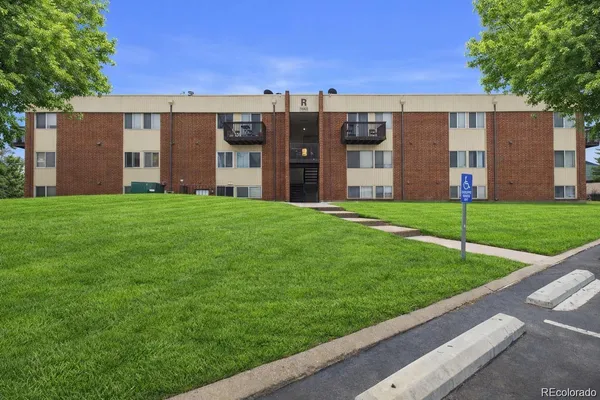 a view of a big building with a big yard and large trees