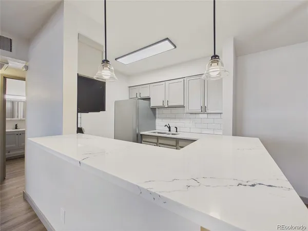 a kitchen with stainless steel appliances a refrigerator sink and white cabinets