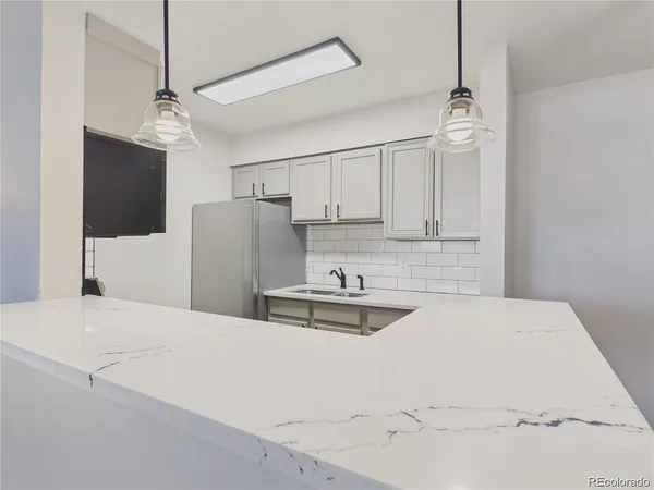 a kitchen with kitchen island a refrigerator a sink and a stove
