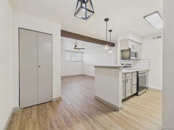 a kitchen with stainless steel appliances granite countertop a refrigerator and a stove top oven