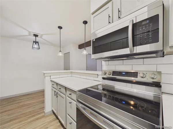 a kitchen with a stove and white cabinets