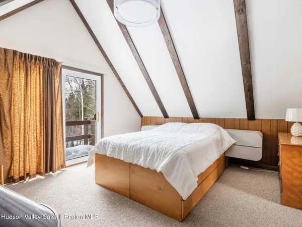 a bedroom with a bed a rug and a large window