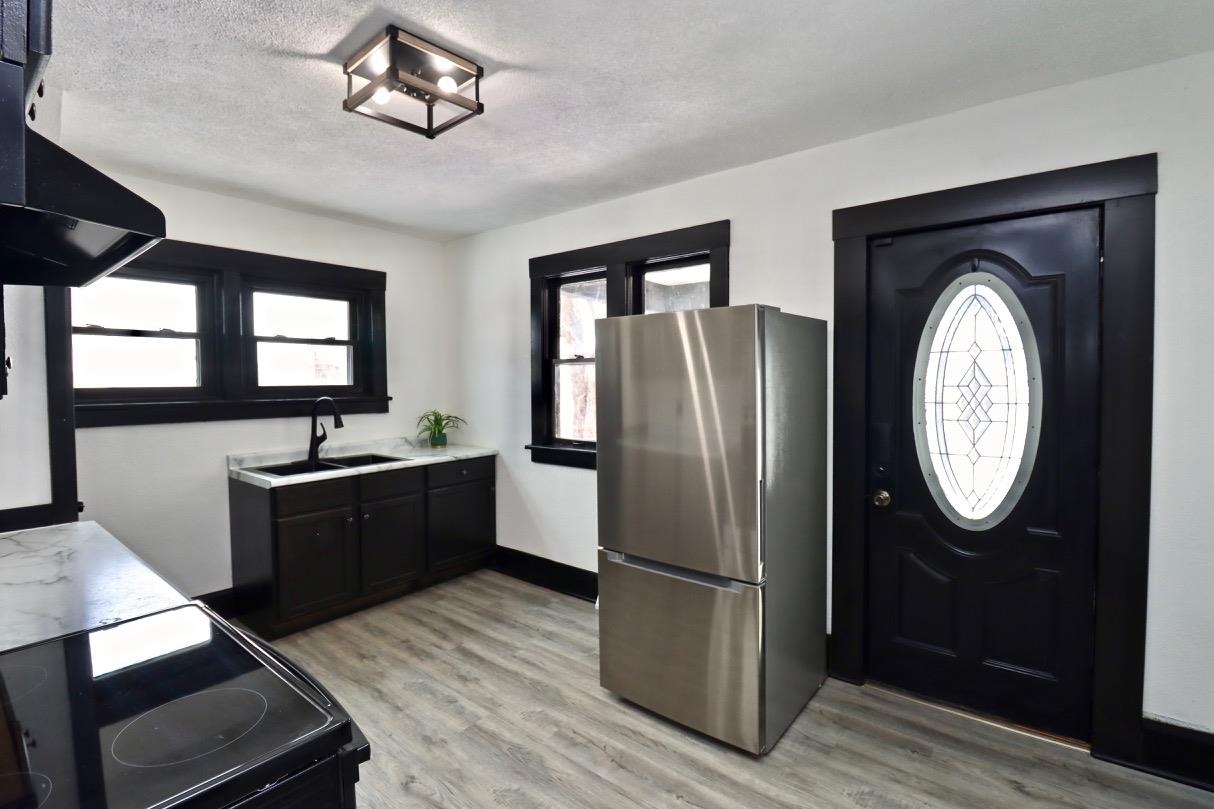15738 Farm School Road Durand, IL 61024 - Photo 3 of 20 a kitchen with stainless steel appliances granite countertop a refrigerator a oven a sink with a dining table and chairs