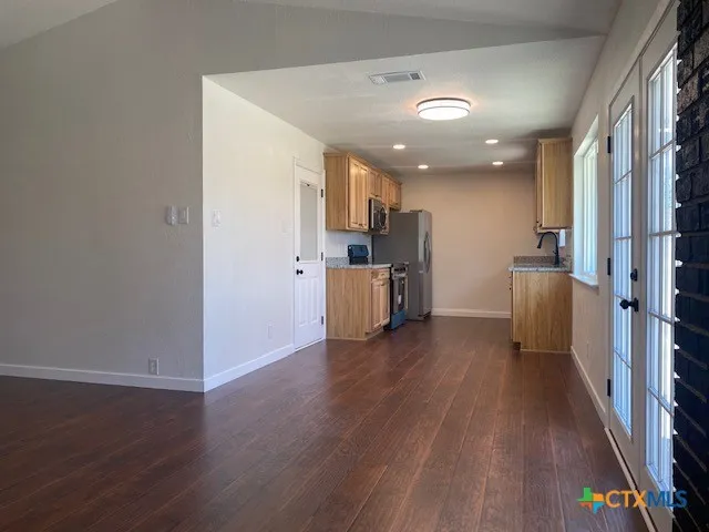 a kitchen with stainless steel appliances granite countertop a stove a sink and a microwave