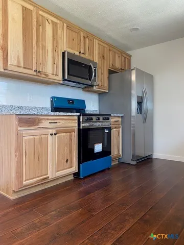 a kitchen with granite countertop wooden cabinets a sink and dishwasher