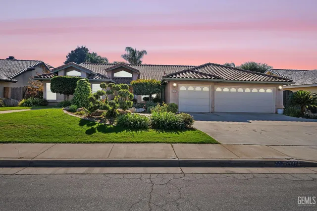 a front view of a house with a yard and a garage