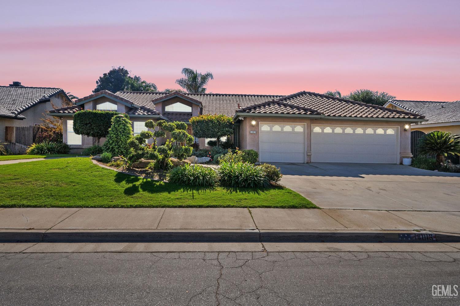 a front view of a house with a yard and a garage