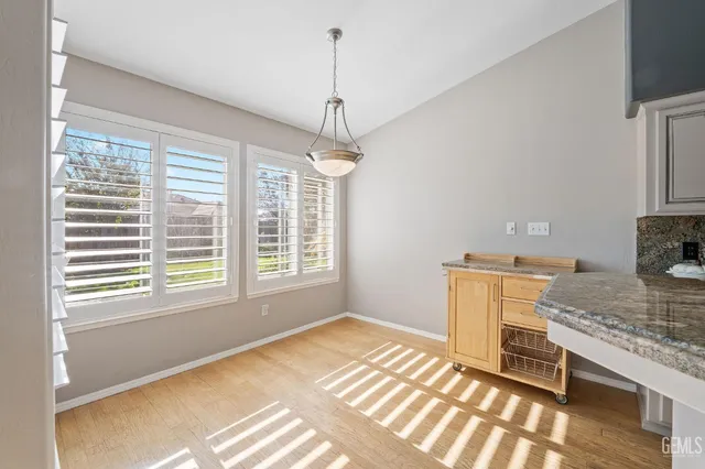 a kitchen with kitchen island a stove a sink and a granite counter tops