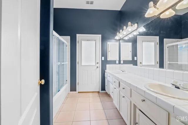a spacious bathroom with a double vanity sink and a mirror