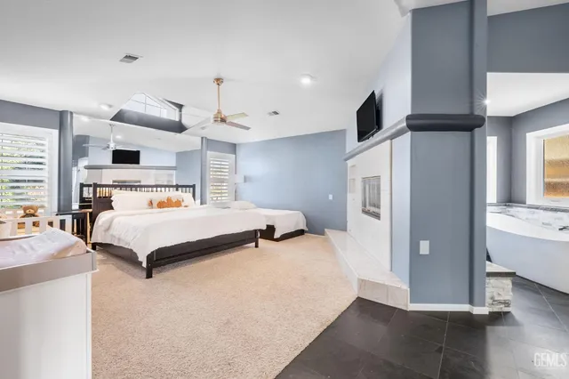 a bedroom with a large bed and a chandelier