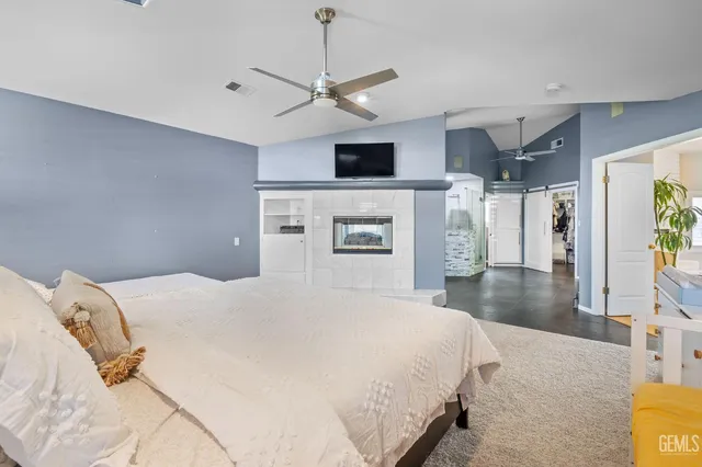 a spacious bedroom with a bed and a flat screen tv