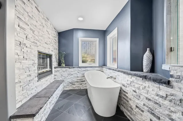 a spacious bathroom with a tub sink and mirror