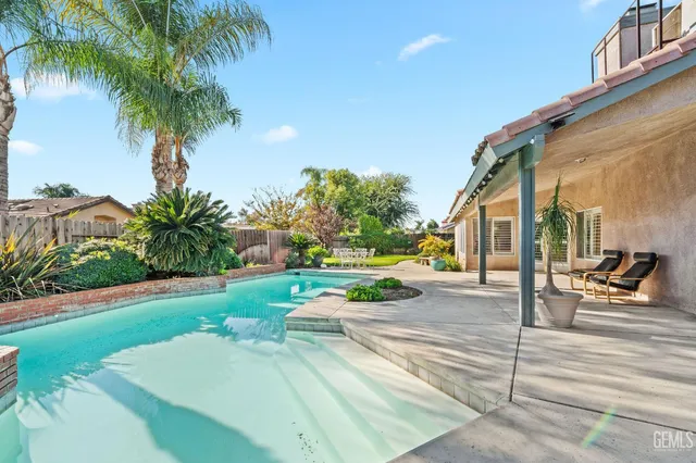 a view of a house with backyard and sitting area