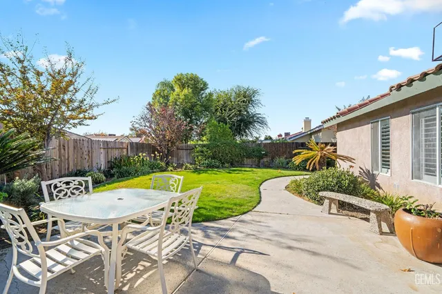 a view of a patio with table and chairs potted plants with wooden fence