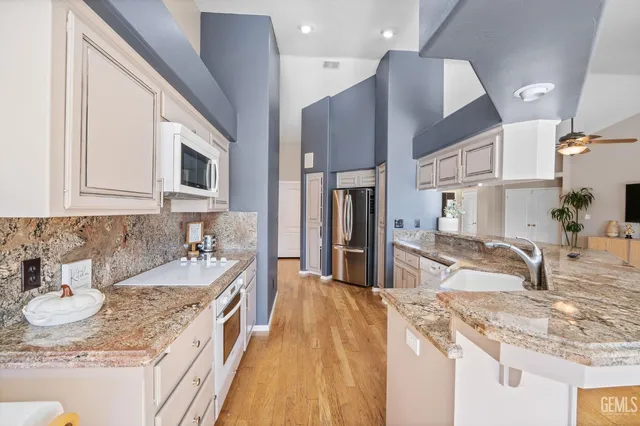 a kitchen with stainless steel appliances granite countertop a sink stove and refrigerator