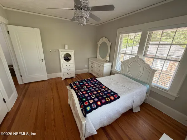 a bedroom with a bed dresser and a window