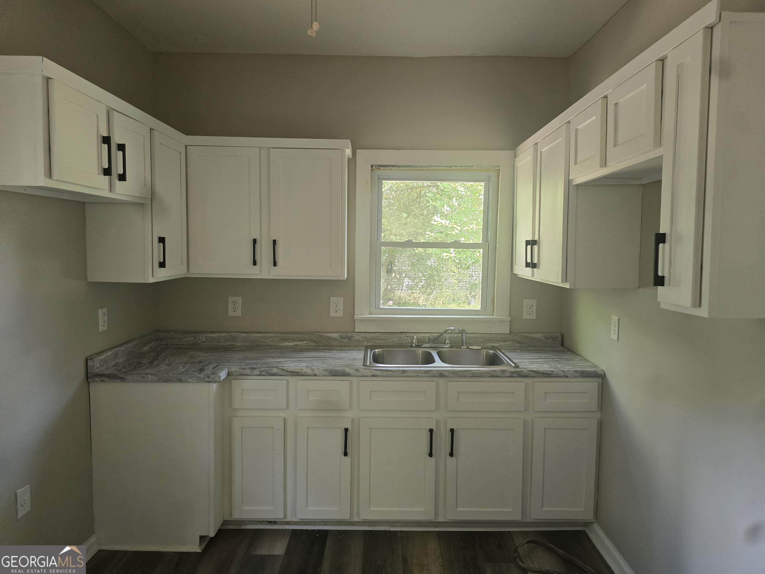 503 Tennessee Street Dublin, GA 31021 - Photo 4 of 8 a sink with granite countertop white cabinets and a sink