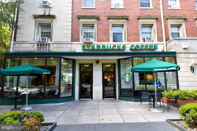 a view of a cafe with a table and chairs under an umbrella