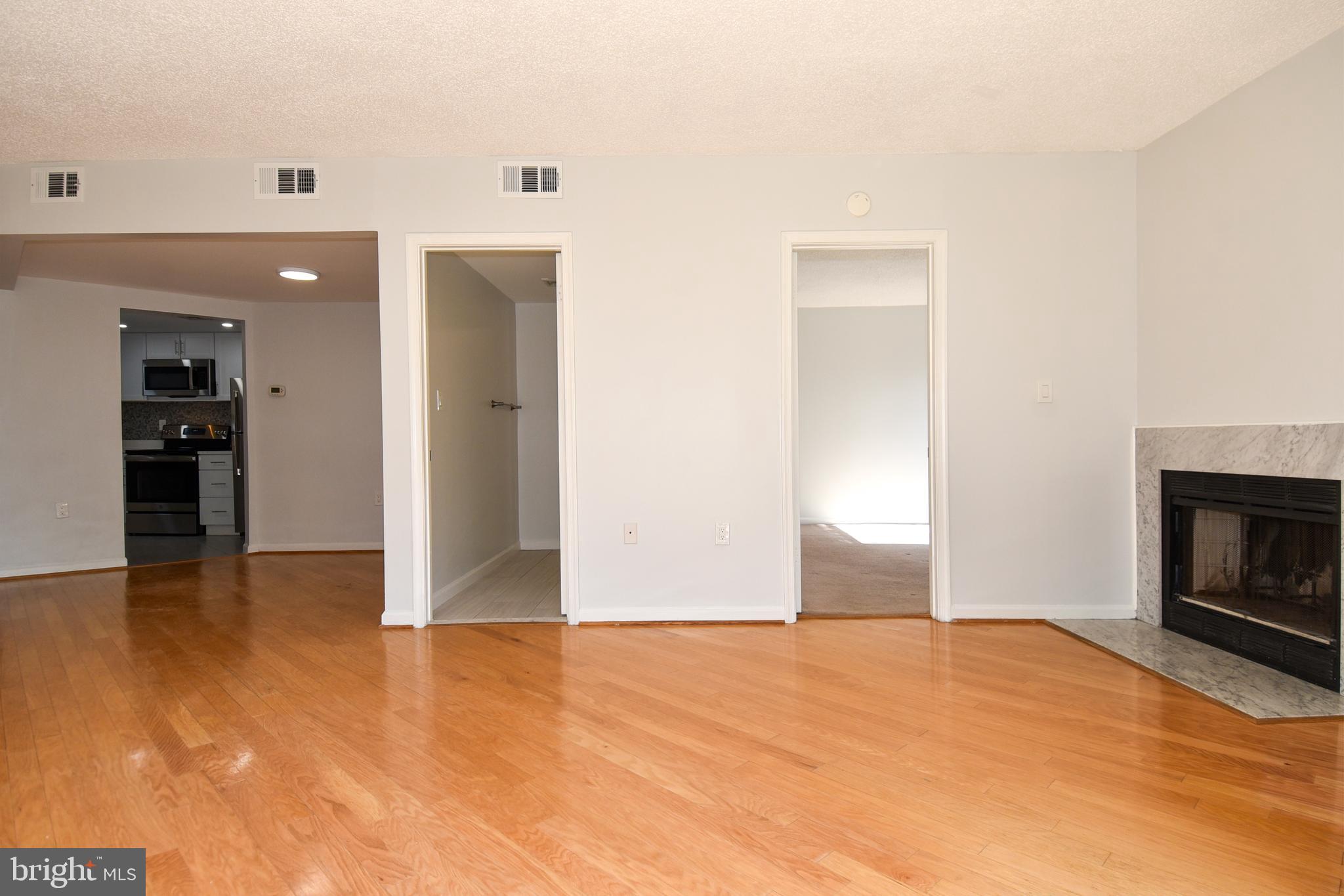 2725 Connecticut Avenue Northwest, Unit 403 Washington, DC 20008 - Photo 7 of 25 a view of empty room with wooden floor and fireplace