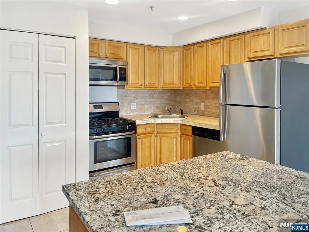 8913 Riverside Place, Unit 3 North Bergen, NJ 07047 - Photo 6 of 17 a kitchen with a sink stove and refrigerator