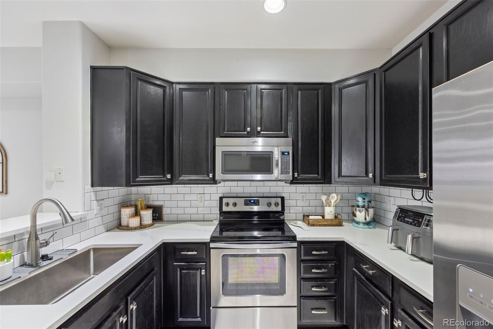 8419 Stonybridge Circle Highlands Ranch, CO 80126 - Photo 11 of 24 a kitchen with a sink stove top oven and cabinets