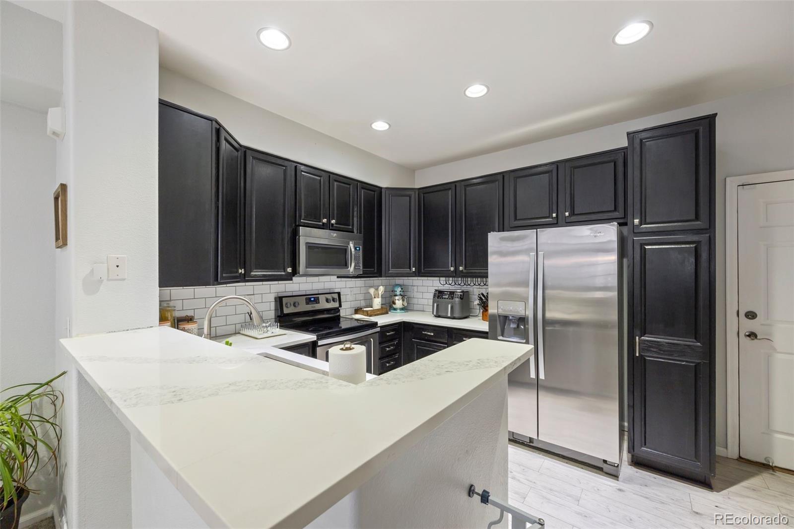 8419 Stonybridge Circle Highlands Ranch, CO 80126 - Photo 10 of 24 a kitchen with kitchen island a sink stainless steel appliances and cabinets