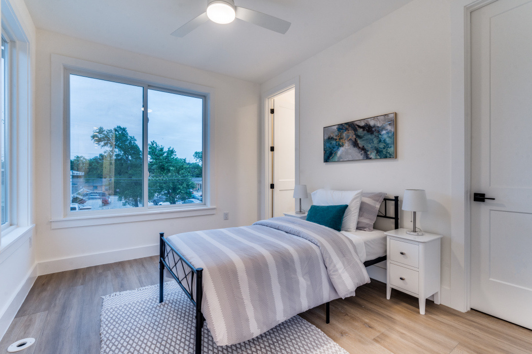 3101 Lyons Road Austin, TX 78702 - Photo 7 of 11 a bedroom with a bed a window and a potted plant