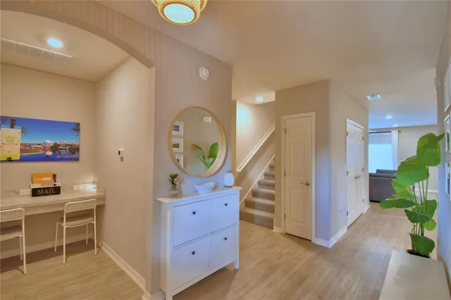 a kitchen with a sink dishwasher and white cabinets with wooden floor